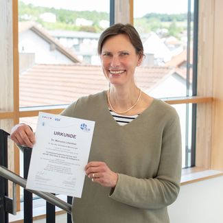Eine IFB-Eigenschenk-Mitarbeiterin mit ihrem Zertifikat