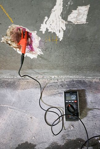 ein Messgerät neben einer alten Betonwand