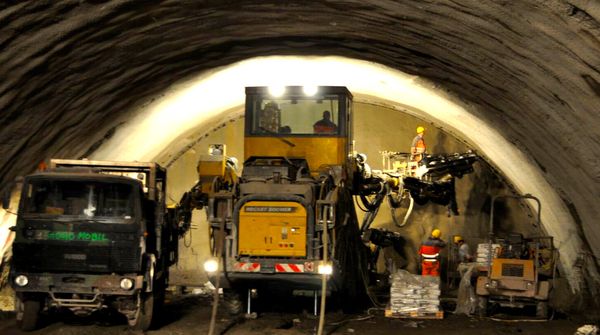 Baustelle im Tunnel Silberberg mit Baufahrzeugen und Arbeitern beim Tunnelvortrieb