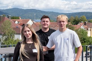 Die drei neuen Azubis von IFB Eigenschenk stehen auf der Dachterrasse