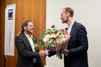 Christian Vrielink überreicht Dr. Bernd Köck einen Blumenstrauß zur Verabschiedung