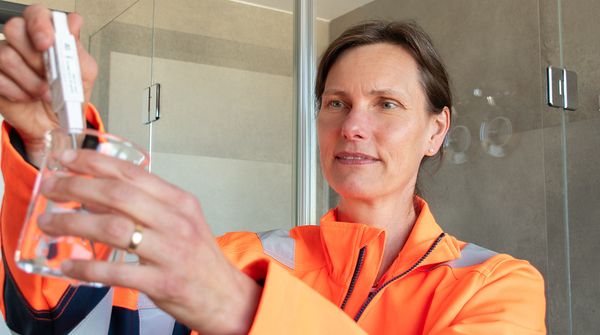 Eine IFB-Eigenschenk-Mitarbeiterin mit einer Wasserprobe