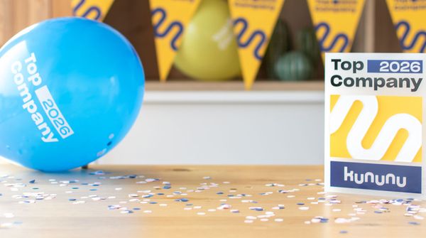 Der Kununu Top Company Award im IFB Eigenschenk Büro, daneben ein blauer Luftballon, im Hintergrund eine gelbe Kununu-Girlande