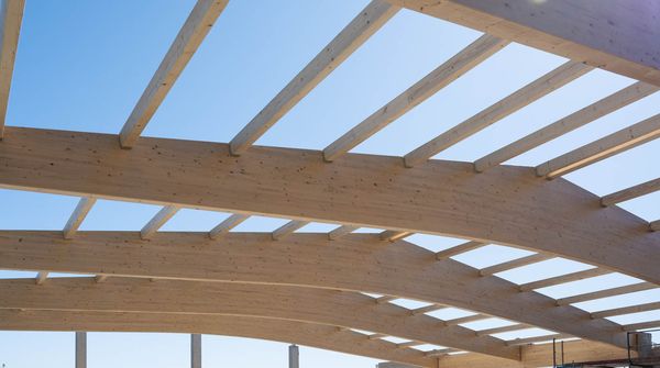 Holz-Dachbinder eines Gewerbebaus während der Rohbauphase mit sichtbarer Tragwerkskonstruktion